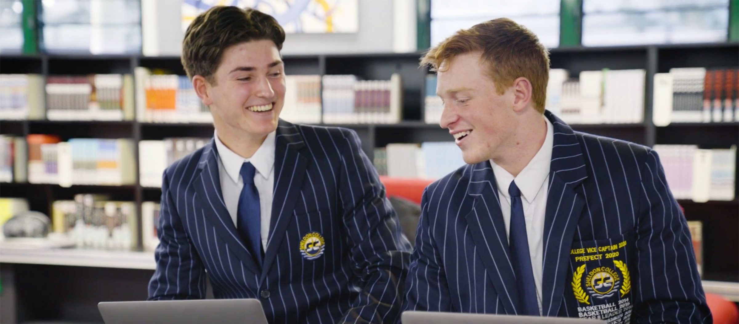 photo of Xavier and another student talking in the library